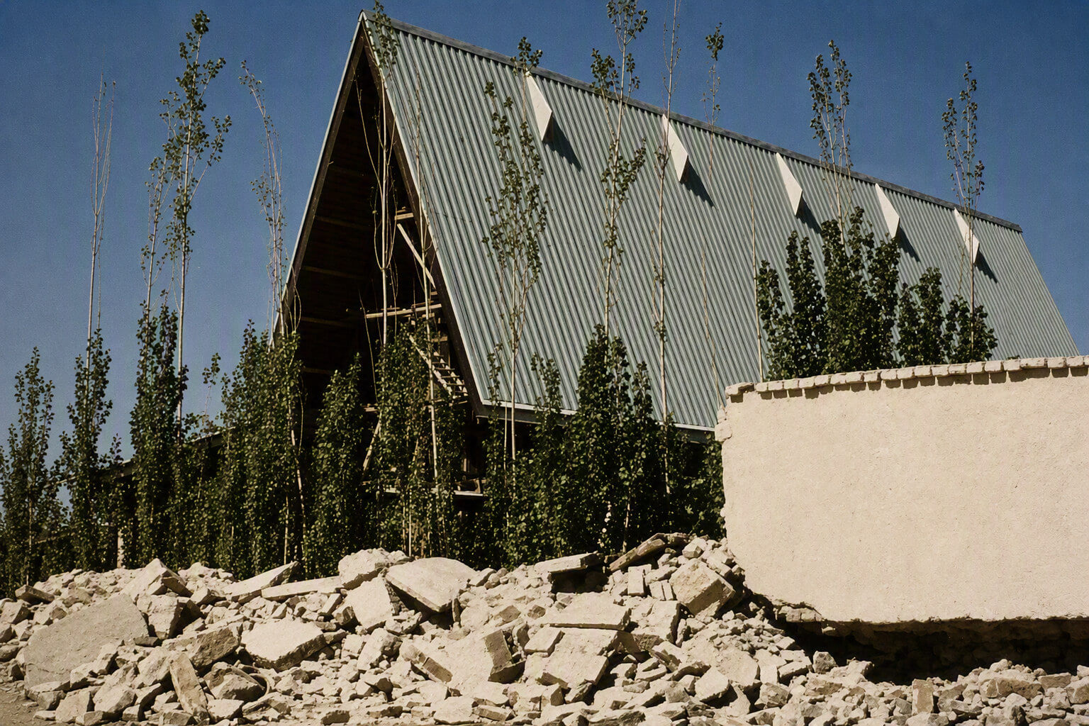 The Kabul church building, its perimeter wall part-demolished and rubble in the foreground