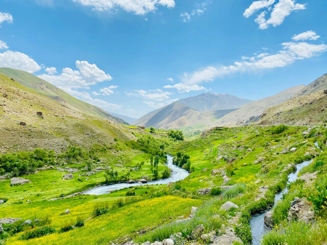 Two small streams winding through a green mountain valley in the upper Panjshir